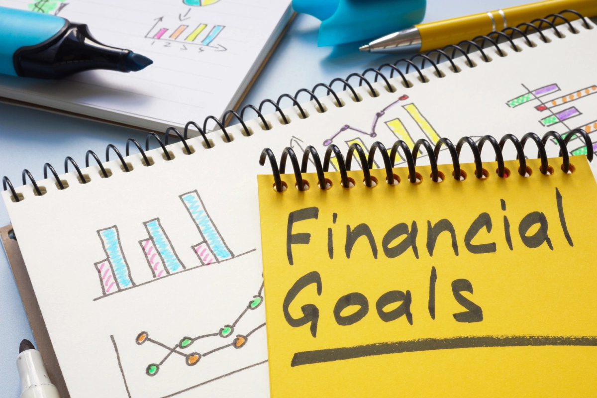 Financial goals written on a yellow notepad.